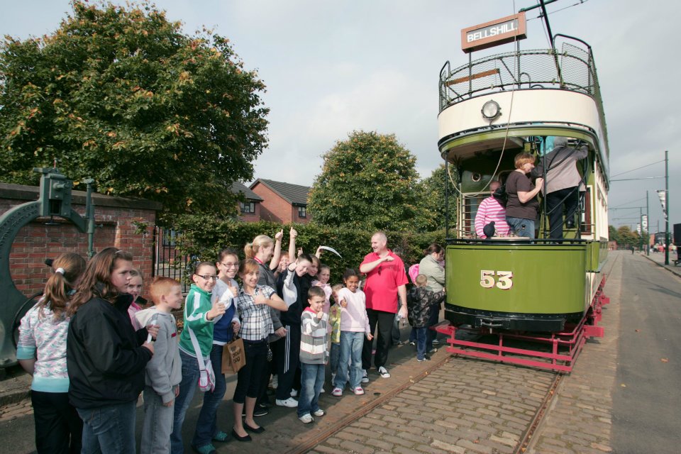 Image of tram with crowd of people waving