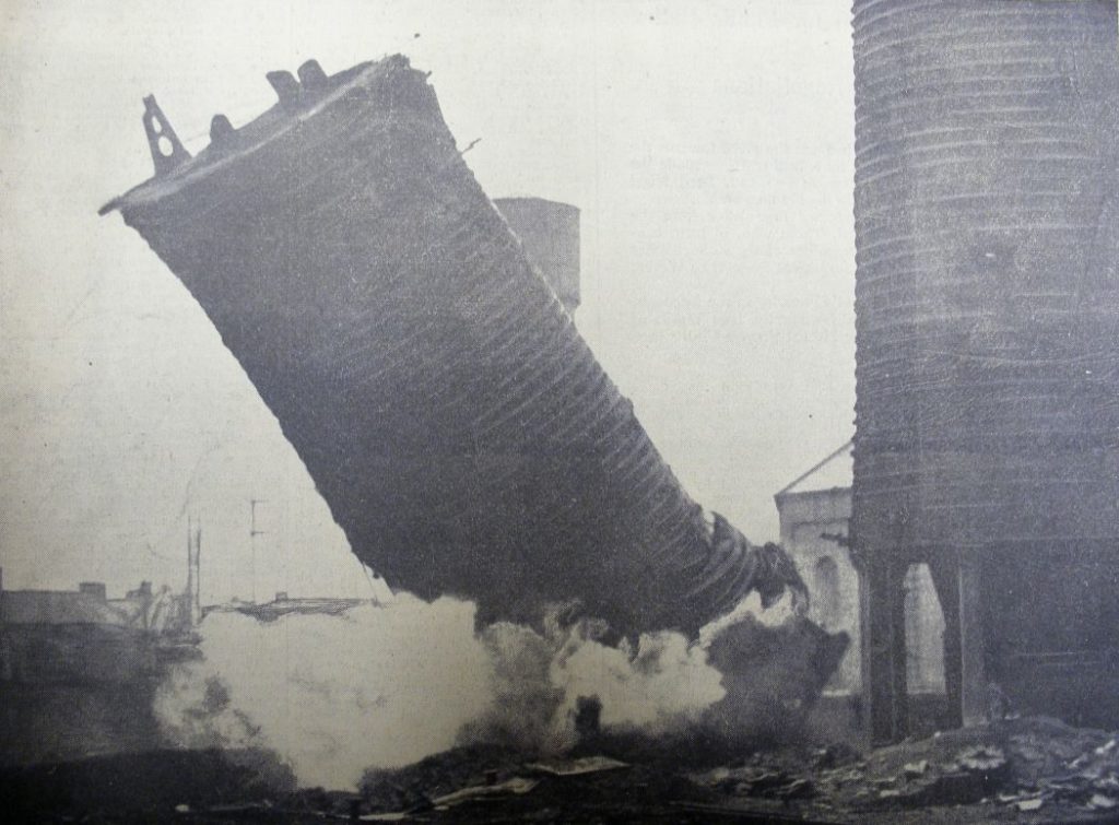 The southernmost of the Summerlee blast furnaces being brought down by gelignite in 1938