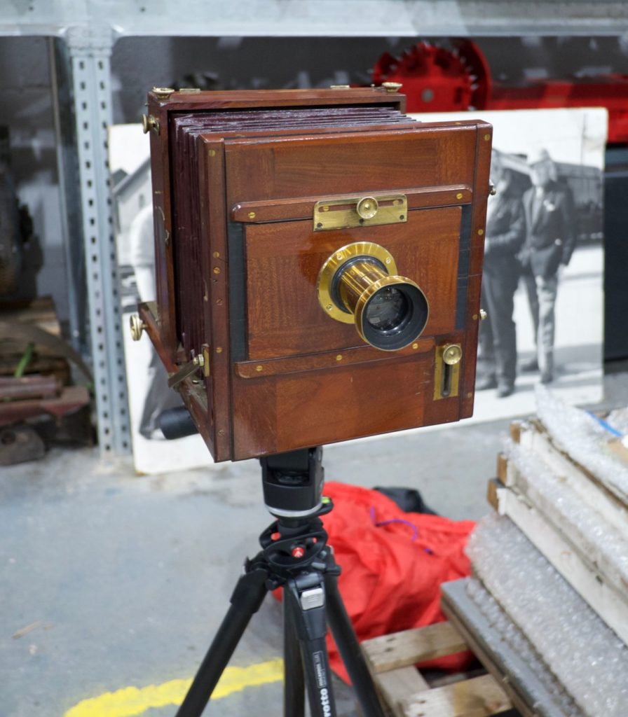 The late 1800s tailboard camera set-up on a modern tripod in the museum store.