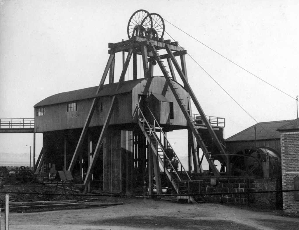 Pit head winding gear at Camp Colliery near Motherwell around 1910. The brick building on the right houses the winding engine and the shaft is directly below the wheels of the head gear.
